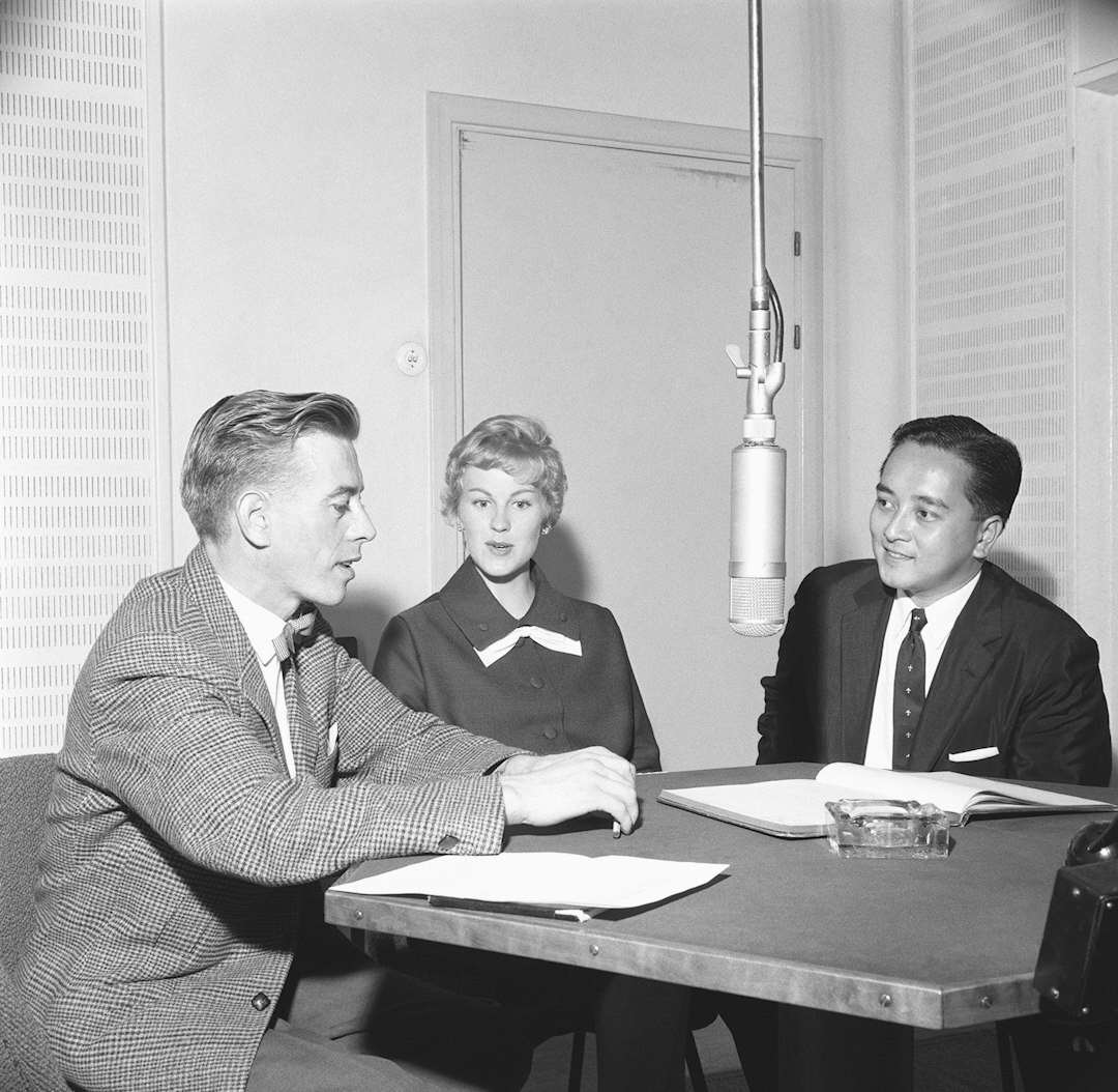 Diverse team meeting around a table discussing a broadcast plan
