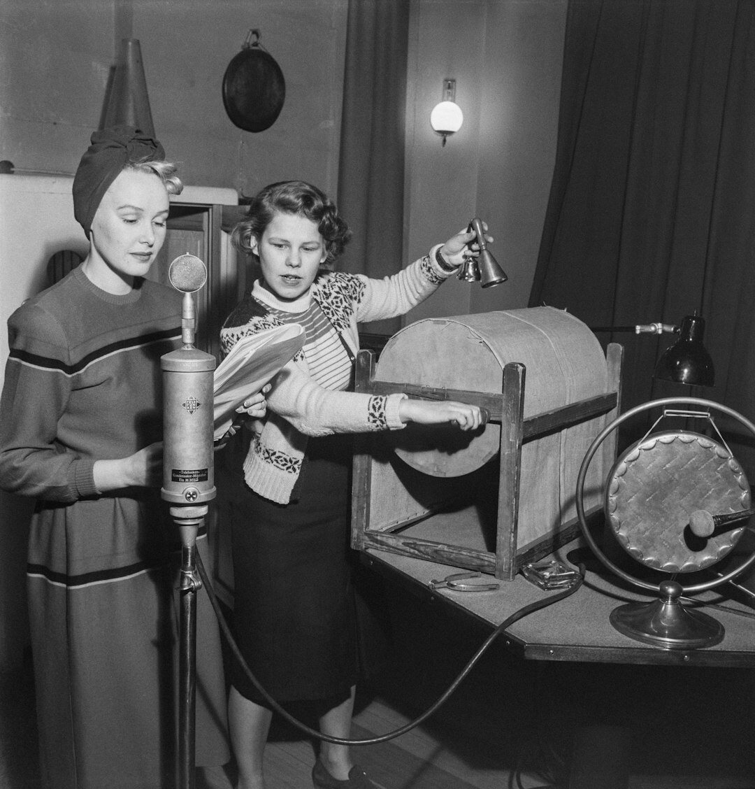 Instructor showing camera settings to a trainee in a studio